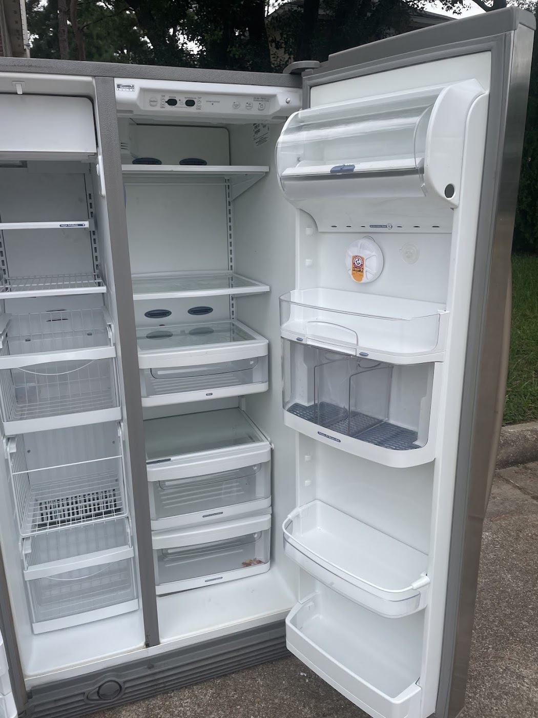 Emptied side-by-side refrigerator with both doors open